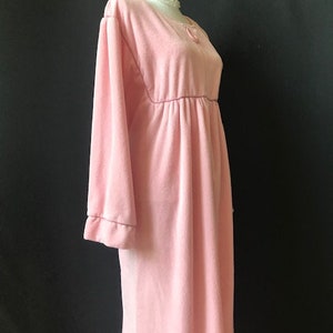 May include: A long, pink, velour robe with long sleeves and a gathered waist.