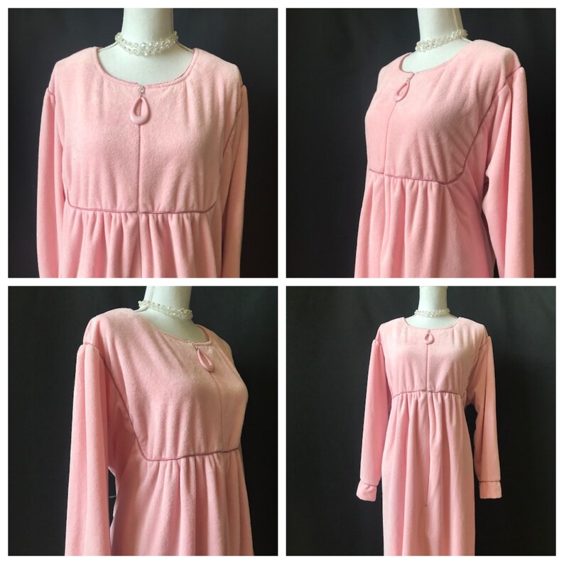 May include: A pink long-sleeved robe with a zipper closure and a gathered waist.