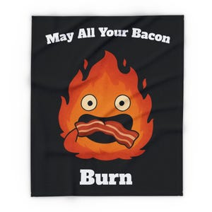 Może przedstawiać: Czarny koc z postacią płomienia z kreskówki, trzymającą bekon i ze zdziwioną miną. Tekst "May All Your Bacon Burn" znajduje się nad płomieniem, a pod nim "Burn". Projekt wykorzystuje kolory pomarańczowy, czerwony i biały.