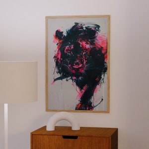 May include: A framed abstract painting of a lion's head in shades of pink, black, and white. The lion's face is rendered in a bold, expressive style with visible brushstrokes.