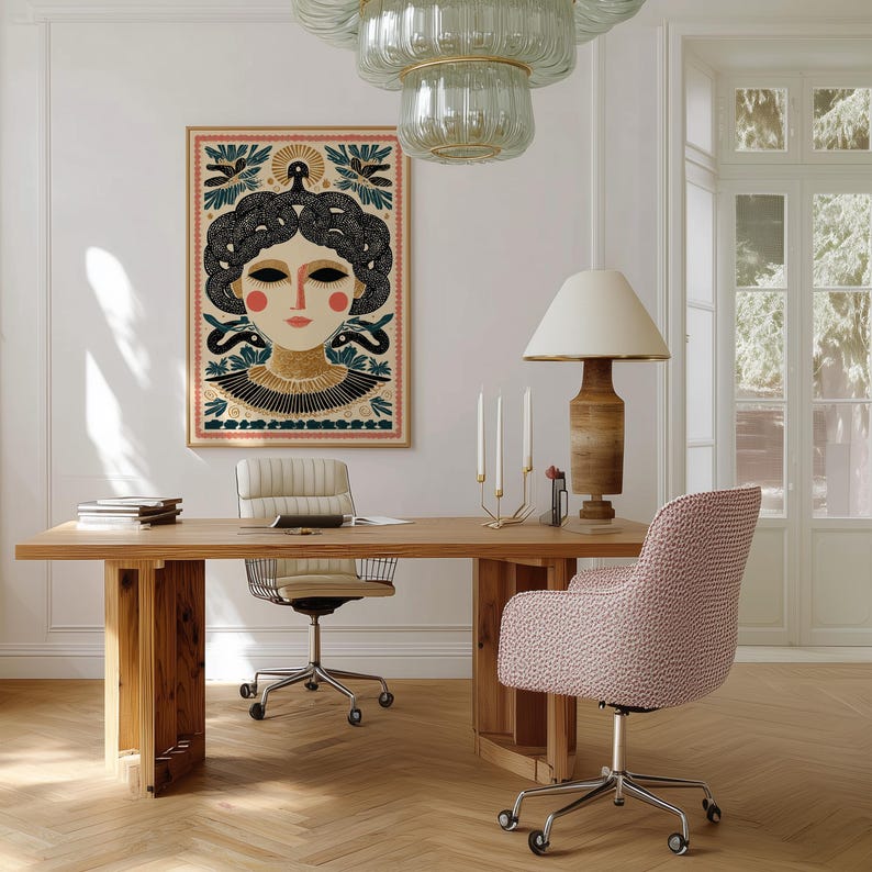 May include: A wooden desk with a framed artwork featuring a woman's face with dark hair and red cheeks. A beige office chair and a pink patterned chair are positioned at the desk. A wooden lamp and a chandelier hang above the desk.