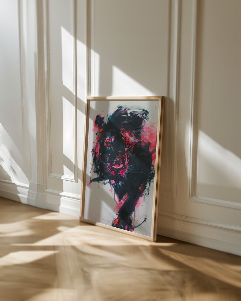 May include: A framed abstract painting of a lion with pink, black, and white paint. The lion is facing forward with its mouth slightly open. The painting is in a wooden frame.