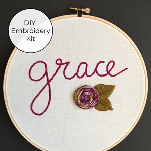 May include: DIY embroidery kit featuring the word "grace" in pink thread with a pink and green embroidered flower.