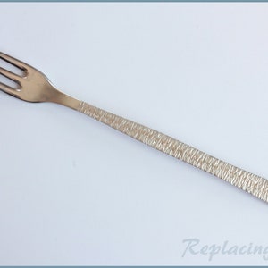May include: A silver fork with a textured handle. The fork is designed for eating salad or dessert.