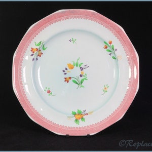 May include: A white ceramic dinner plate with a pink scalloped edge and a floral design in shades of yellow, orange, red, purple, and green.