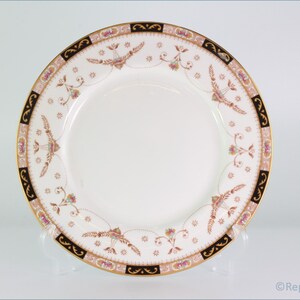 Op de afbeelding: Een wit keramiek dinerbord met een gouden en zwarte rand. De rand heeft een bloemmotief met roze, blauwe en gouden accenten.