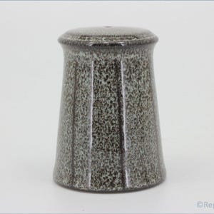 May include: A speckled gray and black ceramic salt shaker with a rounded top and a cylindrical body.