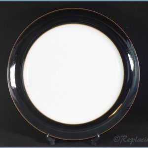May include: A white dinner plate with a wide black rim and a thin gold accent around the edge.