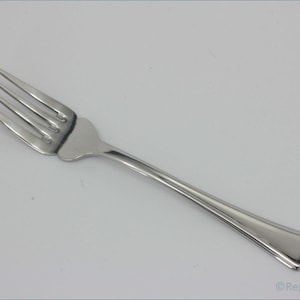 May include: A silver fork with a simple design. The fork has four tines and a smooth handle.
