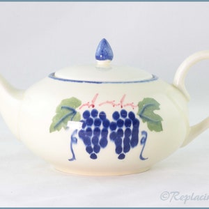 Könnte beinhalten: Eine weiße Teekanne aus Keramik mit einem blauen und grünen Traubenmuster. Die Teekanne hat einen Deckel mit einem kleinen Knopf oben.