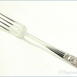 Puede incluir: Tenedor de plata con un mango decorativo con un diseño floral. El tenedor tiene un acabado liso y pulido.