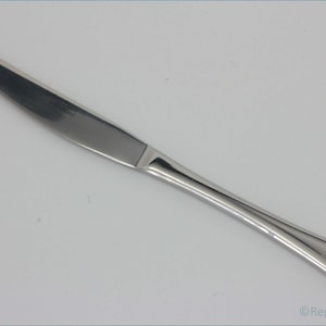 May include: A silver dinner knife with a slightly curved handle. The knife has a smooth, polished finish.