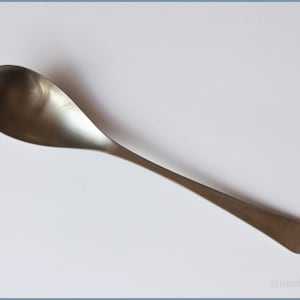 May include: A silver teaspoon with a rounded bowl and a long, slender handle.