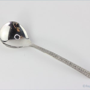 May include: A silver spoon with a textured handle. The spoon has a rounded bowl and is designed for serving.