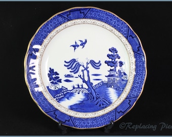 May include: Blue and white porcelain plate with a gold rim and a traditional willow pattern design. The plate features a willow tree, a bridge, a pagoda, and two birds in flight.