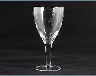 May include: A clear glass wine goblet featuring a smooth, rounded bowl that tapers toward a slender stem and a circular base. The glass is transparent and reflects light, showcasing a simple, functional design for serving beverages.