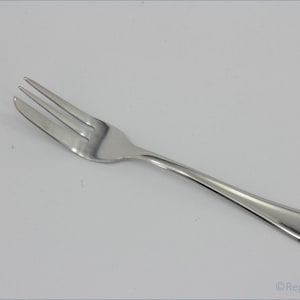 May include: A silver cake fork with a simple design. The fork has three tines and a long, slender handle.