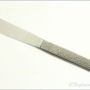 Könnte beinhalten: Ein silbernes Buttermesser mit einem strukturierten Griff.