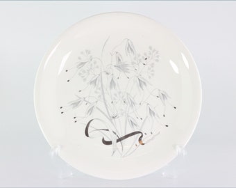 May include: White ceramic plate with a silver floral design. The flowers are stylized and have a delicate, almost watercolor-like appearance.