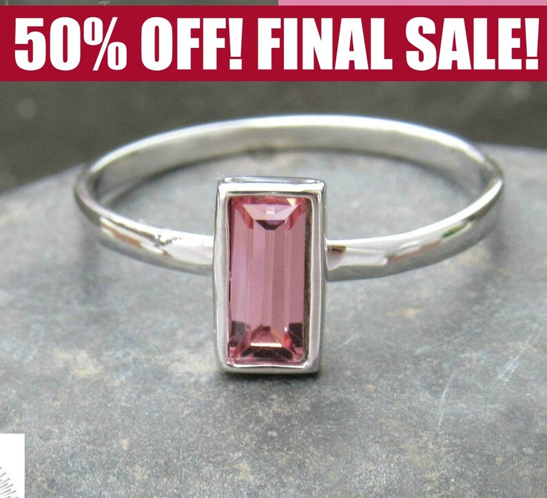 May include: A silver ring with a pink rectangular gemstone set in a silver bezel.
