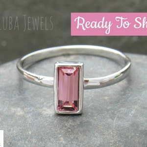 May include: A delicate silver ring with a pink rectangular gemstone. The ring is ready to ship.