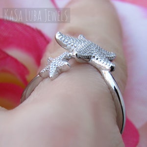 May include: Silver ring with two starfish designs. The ring is adjustable and can be worn on any finger.
