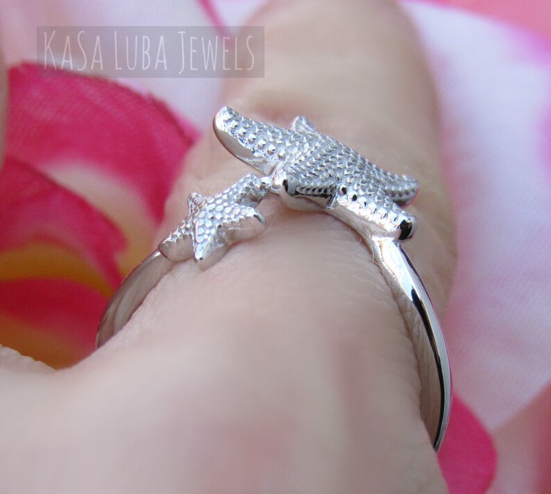 May include: Silver ring with two starfish designs. The ring is adjustable and can be worn on any finger.