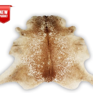 May include: A brown and white cowhide rug with a natural, spotted pattern. The rug is approximately 5 feet long and 4 feet wide.