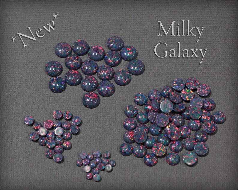 May include: Assortment of Milky Galaxy opal cabochons in various sizes. The cabochons are a mix of dark blue, black, and purple with iridescent flashes of pink and green.  *New*