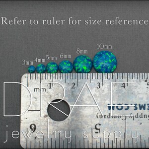 May include: A ruler with a series of round, green and blue opal cabochons, ranging in size from 3mm to 10mm. The ruler is marked in millimeters.