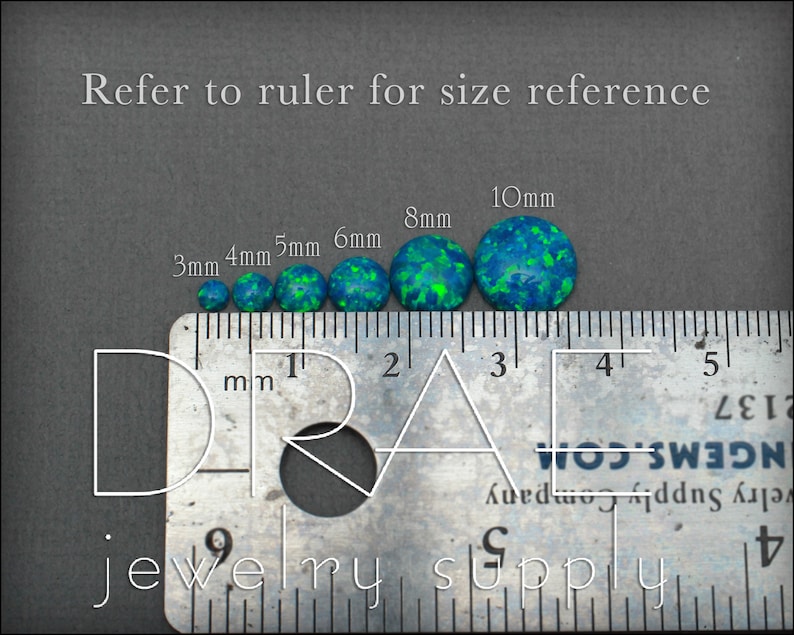 May include: A ruler with a series of round, green and blue opal cabochons, ranging in size from 3mm to 10mm. The ruler is marked in millimeters.