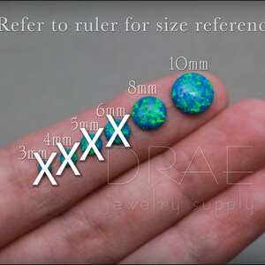 May include: A close-up of a hand holding six different sizes of blue and green opal cabochons. The cabochons are labeled with their size in millimeters: 3mm, 4mm, 5mm, 6mm, 8mm, and 10mm. The text "jewelry supply" is visible below the cabochons.