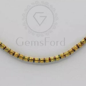 May include: A gold nose ring with a chain of small, textured beads. Each bead has a thin band of colourful enamel.
