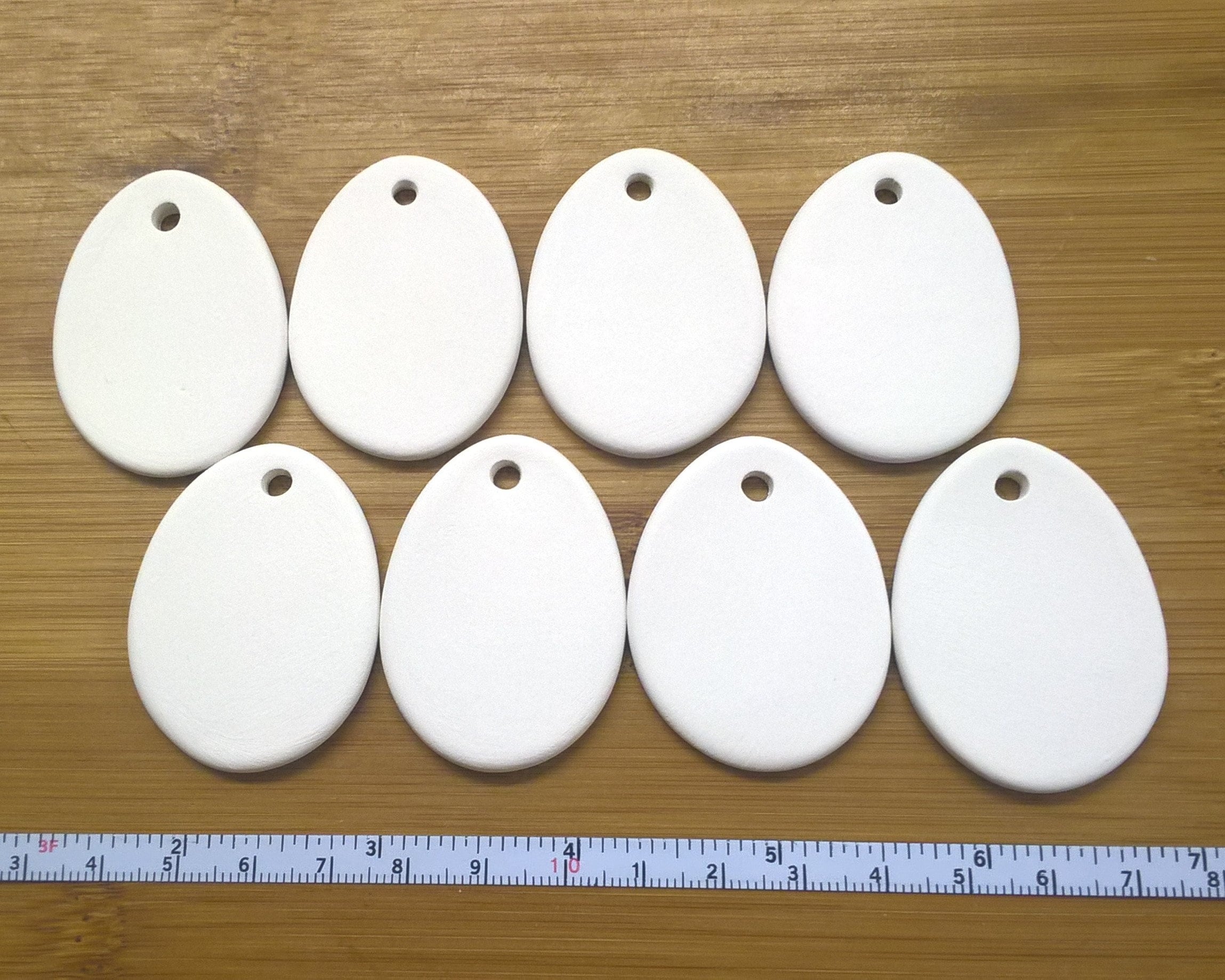 8 oval 4.5cm x 3cm bisque blanks. For painting/decoupage/etc 'cold finish' or pottery kiln firing. Super white earthenware ceramic.
