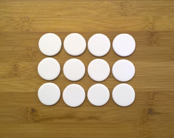 May include: Twelve white round circles arranged in a rectangular pattern on a wooden surface.