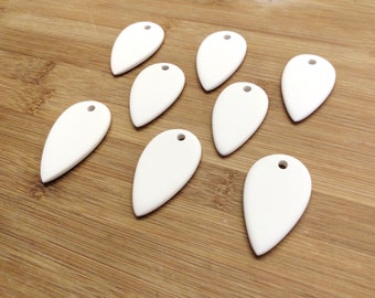 May include: Ten white ceramic teardrop-shaped pendants with a hole at the top for hanging.