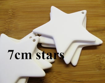 May include: Five white ceramic star ornaments, each measuring 7 cm across. The stars have a hole at the top for hanging.