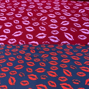Könnte beinhalten: Zwei Stoffmuster mit einem sich wiederholenden Muster aus roten Lippen. Das obere Muster ist dunkelrot mit rosa Lippen. Das untere Muster ist dunkelblau mit roten Lippen.