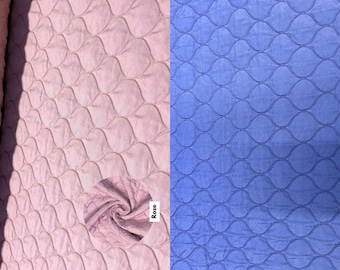 Puede incluir: Dos muestras de tela, una rosa y otra azul, con un patrón acolchado de óvalos superpuestos. La palabra "Rose" está escrita en la muestra rosa.