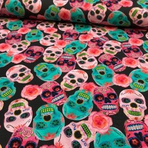 Könnte beinhalten: Schwarzer Stoff mit einem sich wiederholenden Muster aus bunten Zucker Totenköpfen. Die Totenköpfe haben rosa, blaue und grüne Akzente.