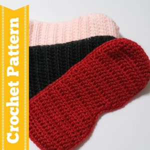 Op de afbeelding: Drie gehaakte slaapmaskers in rood, zwart en roze. De maskers zijn gemaakt met een eenvoudig steekpatroon.