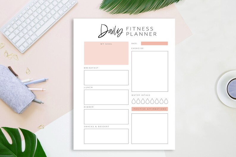 Op de afbeelding: Een printbare dagelijkse fitnessplanner met secties voor doelen, oefening, maaltijden, waterinname en positieve affirmaties. De planner heeft een roze en witte kleurstelling.