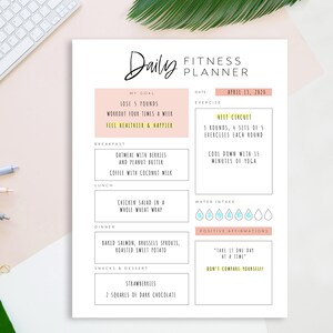 Op de afbeelding: Een printbare dagelijkse fitnessplanner met een roze en gele kleurschema. De planner bevat secties voor doelen, oefening, waterinname, positieve affirmaties en maaltijdplanning. De datum is 13 april 2020.