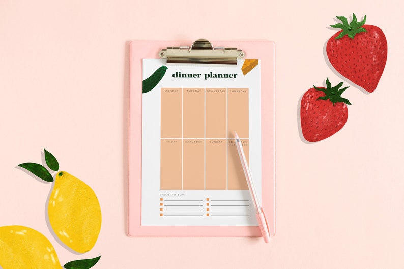 May include: A pink clipboard with a white sheet of paper that says "dinner planner" and has a weekly meal planner grid. The clipboard has a silver clip and a pen is next to it. There are two red strawberries and two yellow lemons on a pink background.
