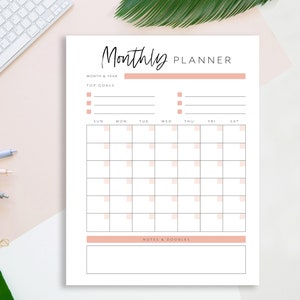 May include: A printable monthly planner with a simple design. It includes sections for month and year, top goals, a calendar grid, and notes and a to-do list.