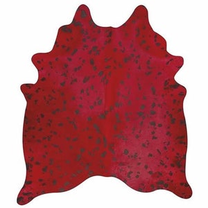 Könnte beinhalten: Roter Kuhfellteppich mit schwarzen Flecken. Der Teppich ist aus natürlichem Kuhfell gefertigt und hat einen einzigartigen, rustikalen Look.