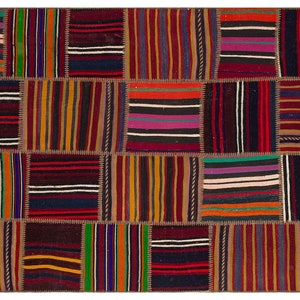 Könnte beinhalten: Ein bunter Patchwork-Teppich mit einer Vielzahl von Streifen in Rot-, Orange-, Gelb-, Grün-, Blau-, Lila- und Brauntönen. Der Teppich ist aus recycelten Materialien hergestellt und hat ein einzigartiges, handgewebtes Design.