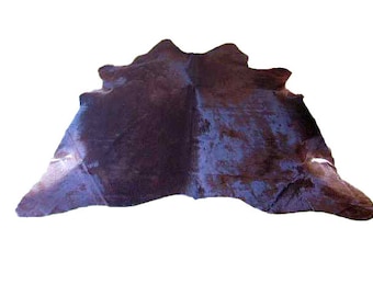 May include: A large, dark purple cowhide rug with a mottled pattern. The rug is soft and supple, with a natural, rustic look.