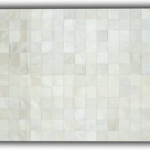 May include: A rectangular, off-white rug with a patchwork design. The rug is composed of numerous square pieces, creating a textured surface. The color is a neutral tone, suitable for various interior styles.