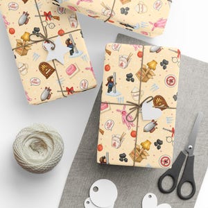 May include: Wrapping paper with a light yellow background featuring a repeating pattern of holiday-themed illustrations including a pink bunny suit, a leg lamp in a box, a radio, a bar of soap, a target, a mug, and the text Oh Fudge in speech bubbles.